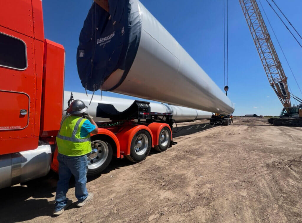 red semi truck with long and wide load guided by angelos transportation